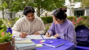 College students planning course schedule at campus library